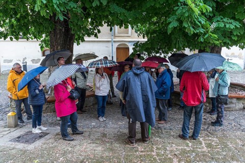 Travel group in case of rain in the courtyard of St. Margaret's Church, Medias, Romania
