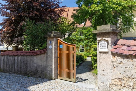 Entrance to the parish office of St. Nicolai through a gate through the wall, behind it historic