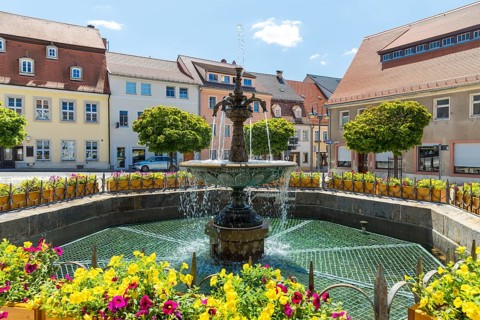 Sandstone market fountain on the medieval market square, in the background the monument to the