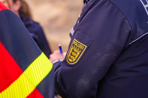 Close-up of a police uniform badge. Writing and coat of arms are visible, fire brigade exercise at