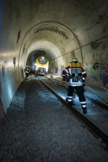 Firefighters with equipment work on rails in a tunnel, fire brigade exercise on the Hermann Hesse