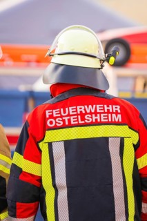 Firefighter from behind wearing colorful protective clothing and helmet, fire department exercise