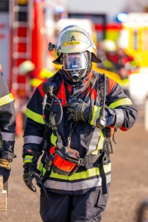 Firefighter wearing full protective clothing during an operation, fire brigade exercise on the