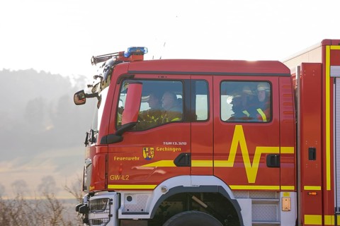 Closer look at a fire engine driving on a street with people inside, fire department exercise on