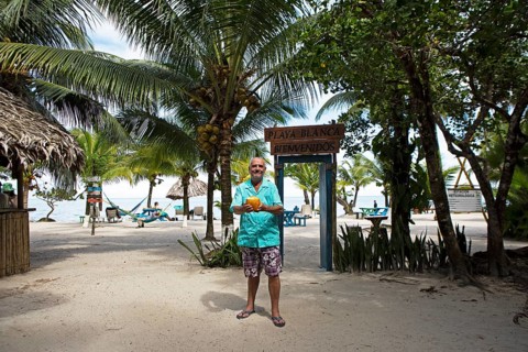 German manager, 67 years old, at Playa Blanca with a coconut, Izabal Department, Guatemala
