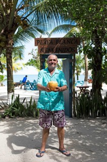 German manager, 67 years old, at Playa Blanca with a coconut, Izabal Department, Guatemala