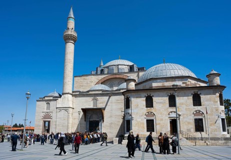 Visitors enter a historic mosque with several domes and minarets, prayer in front of the mosque,