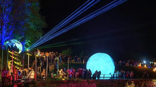 Festival atmosphere with lighting and a large blue ball on a hill, Kronach glows, Frankenwald