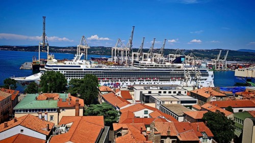 Large cruise ship in port surrounded by port cranes and buildings, Koper, Slovenia