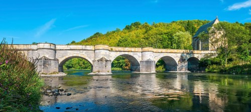 13th century medieval stone bridge across the Werra river, in the back the Liborius chapel,