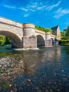 13th century medieval stone bridge across the Werra river, in the back the Liborius chapel,