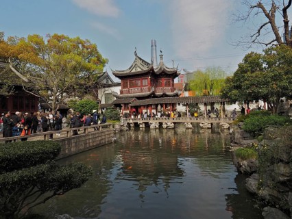 Traditional buildings surround a pond with carp and gardens, Yuyuan Garden, Shanghai, China