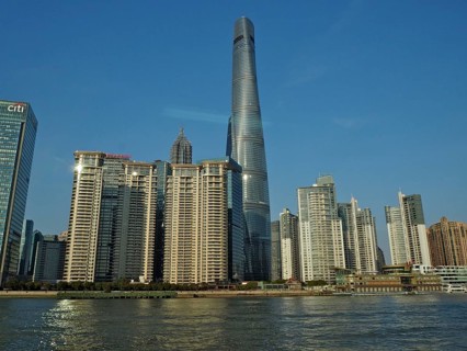 City skyline of Huangpu Jiang with tall modern buildings against blue sky on the water, Pudong,