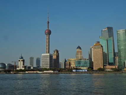 Panorama of a modern skyline of Huangpu Jiang with television tower and water in the foreground,