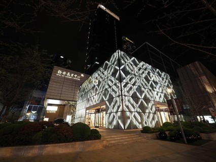 Modern building, Jing An Kerry Centre, at night with illuminated façade in an urban setting,