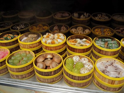 Different types of dim sum carefully arranged in bamboo steamers at a wet market, French