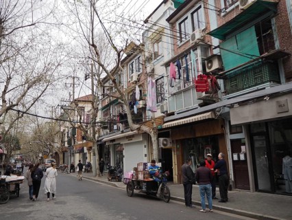 Street scene with pedestrians and residential buildings reflecting everyday life in a lively city,