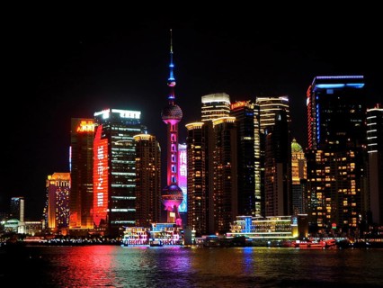 Illuminated skyline with the iconic Oriental Pearl Tower shining in the light at night, Shanghai,