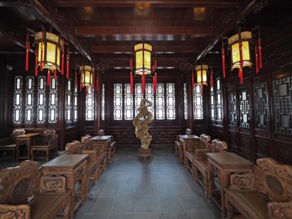 An elegant interior design with Asian lanterns, wood decor, and ornate furniture in warm tones,