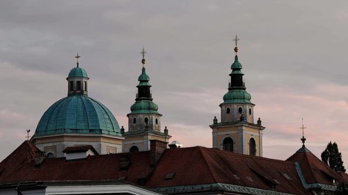 Three church towers and a dome rise against a cloudy evening sky, Piran, Slovenia