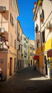 A narrow, colorful alley in a Mediterranean town in bright sunshine, Piran, Slovenia