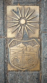 Metal relief with sun symbol and historical depiction on a stone surface, Skopje, North Macedonia