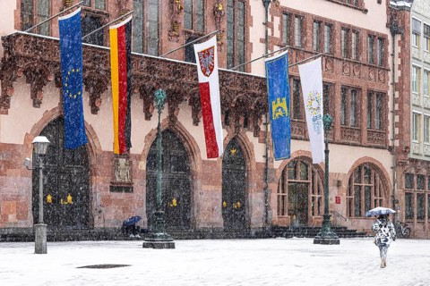 A passer-by walks across Frankfurt's Römerberg with an umbrella. Heavy snowfalls have caused