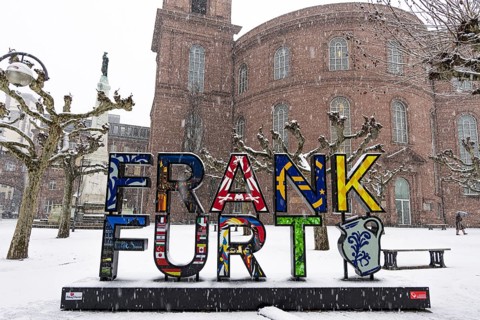 A passerby walks past St. Paul's Church in Frankfurt with an umbrella. Heavy snowfalls have caused