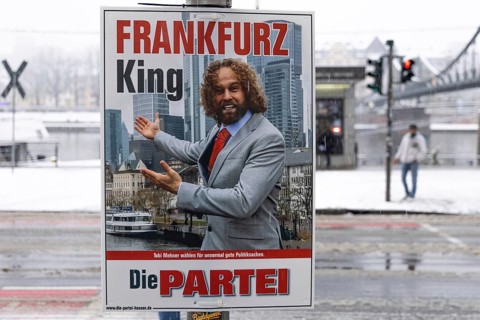 An election poster Fankfarz King - The Party hangs on a lamppost on the banks of the Main in