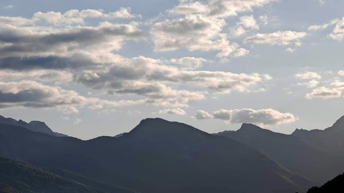 Mountain ranges in the background with clouds in the sky and a calm atmosphere, Peaks of the