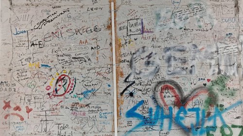 Wall full of colorful graffiti and doodles separating two different sections, Pristina, Kosovo