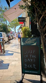 Funny street sign Chalkboard signs outside a café offering beer as soup of the day on a sunny day,