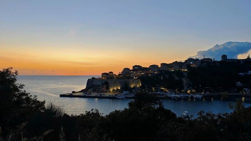 Coastal town at sunset, illuminated silhouette and calm sea, Ulcinj, Montenegro