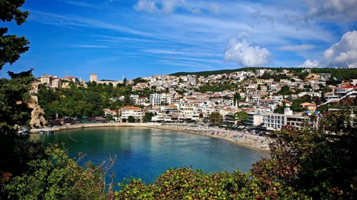 Picturesque coastal town on a bay under blue sky, surrounded by greenery, view of Ulcinj,