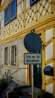 Half-timbered house with a humorous street sign, decorated in historic colors, Upper Franconia