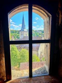 View from a rustic window of a village with a church under a clear summer sky, Upper Franconia
