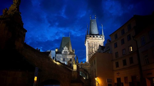 Night view of impressively illuminated historic towers and buildings, Prague
