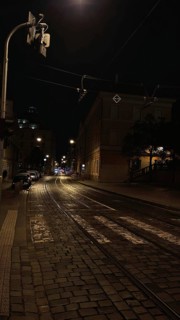 Dark, paved street with street lights leading into darkness, Prague, Czech Republic