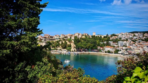 Panoramic view of a coastal town with boats and hills surrounded by clear skies, view of Ulcinj,