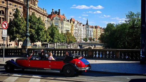Driving a classic car, sightseeing, sightseeing along a street lined with historic buildings in