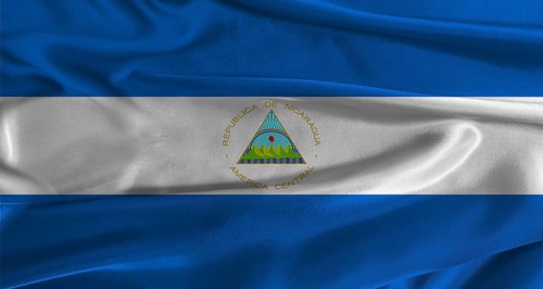 Flag of Nicaragua with fabric textured background. Close up of National flag of Nicaragua with