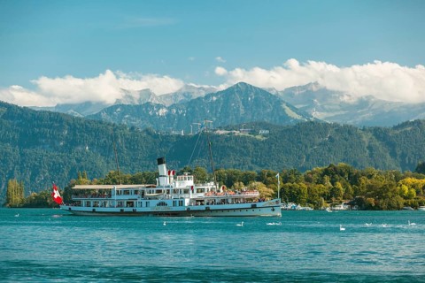 Lake Lucerne, Switzerland, Europe. A traditional boat on Lake Lucerne with the Swiss Alps in the
