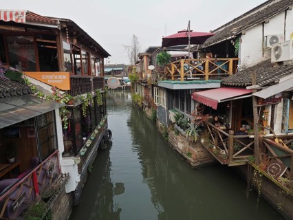 Charming rustic buildings with plants and wood elements along a quiet canal, Zhujiajiao Ancient