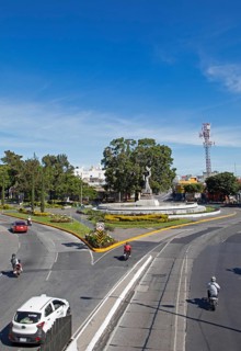 Street scene in zone 14 with the Peace Memorial or Monumento de la Paz in the back, Guatemala City,