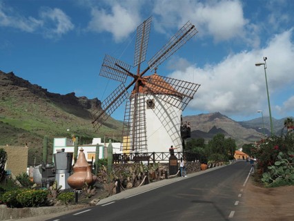 Traditional windmill along a road against a mountainous backdrop, Mogan windmill, Gran Canaria,