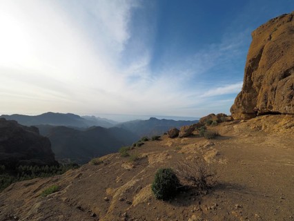 Wide, rocky landscape with views of distant mountains under blue sky, Roque Nublo, Gran Canaria,