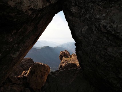 View through a rocky frame of a distant mountain landscape, Roque Nublo, Gran Canaria, Canary