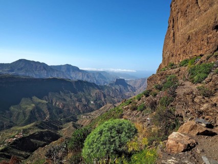 View of a deep valley and distant mountains from a mountain trail, Roque Bentayga, Gran Canaria,