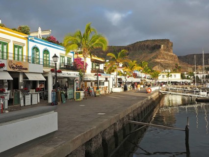 Picturesque harbor promenade with colorful buildings and palm trees, Puerto de Mogan, Gran Canaria,