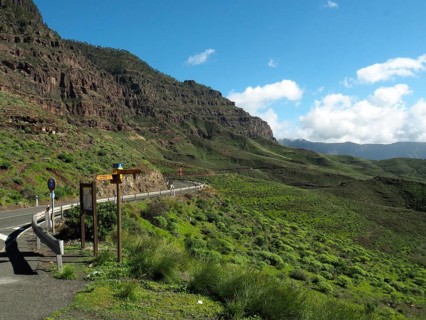 Scenic road through green mountains with clear skies, GC 200 near La Aldea de San Nicolas, Gran